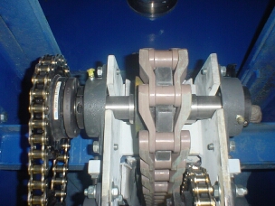 Double reduction chain drive for polymeric chain driven plate conveyor